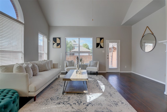 living room with dark wood finished floors, baseboards, and high vaulted ceiling