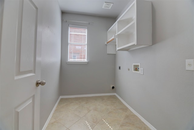 washroom with electric dryer hookup, hookup for a gas dryer, hookup for a washing machine, light tile patterned floors, and baseboards