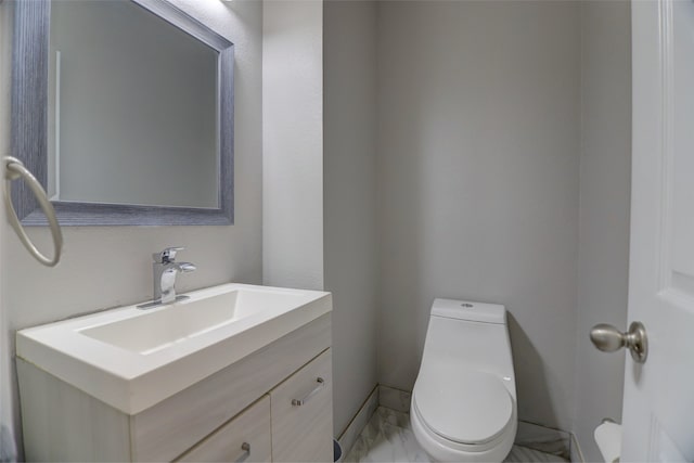 bathroom with toilet, baseboards, vanity, and marble finish flooring