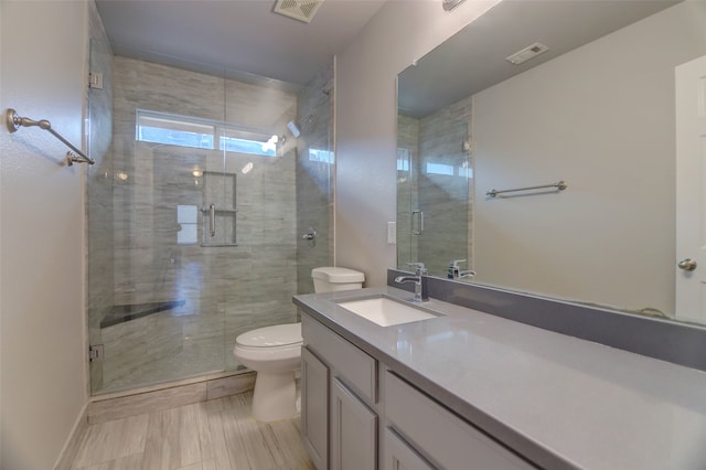 full bath featuring toilet, a stall shower, and vanity