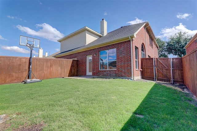 back of property featuring a chimney, a gate, brick siding, and roof with shingles