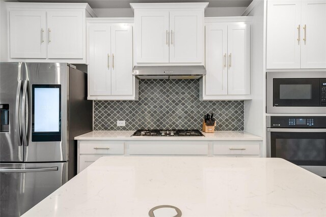 2507 Henley Way, Mansfield, TX 76084 - kitchen with appliances with stainless steel finishes, range hood, white cabinets, and backsplash