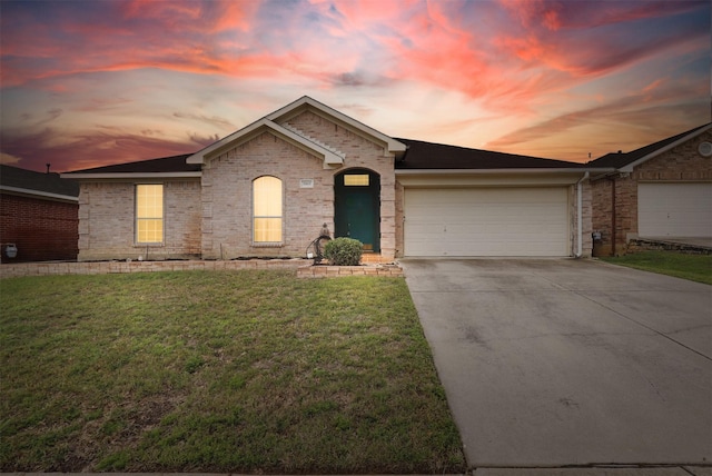 ranch-style home with an attached garage, a front lawn, driveway, and brick siding