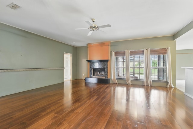 unfurnished living room featuring a fireplace, a ceiling fan, wood finished floors, and baseboards