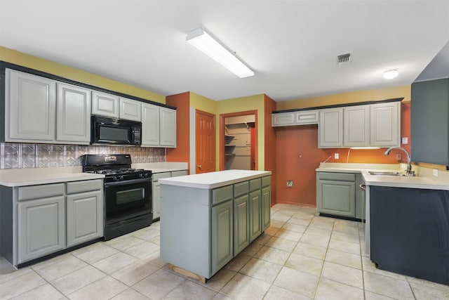 kitchen featuring black appliances, a sink, decorative backsplash, light countertops, and a center island