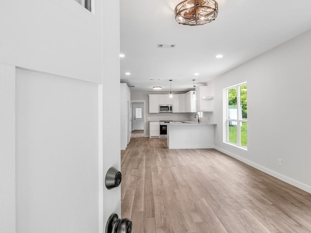 610 SW 3rd St, Kerens, TX 75144 - unfurnished living room featuring recessed lighting, light wood finished floors, baseboards, and a sink