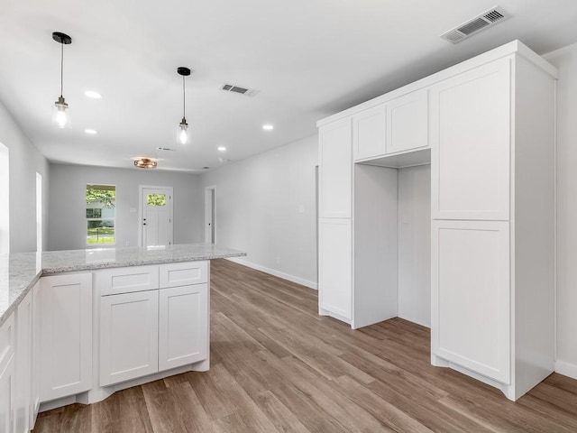 610 SW 3rd St, Kerens, TX 75144 - kitchen featuring light wood-style flooring, white cabinets, recessed lighting, hanging light fixtures, and light stone countertops