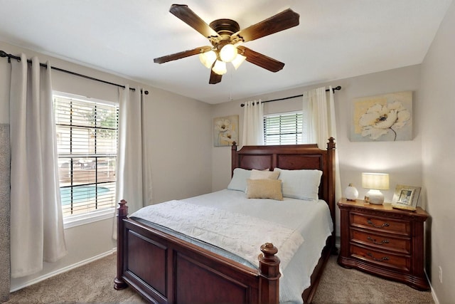 bedroom featuring light colored carpet, baseboards, and ceiling fan