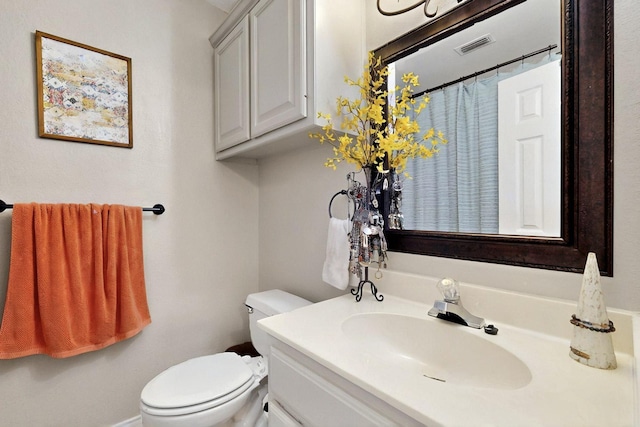bathroom featuring toilet and vanity