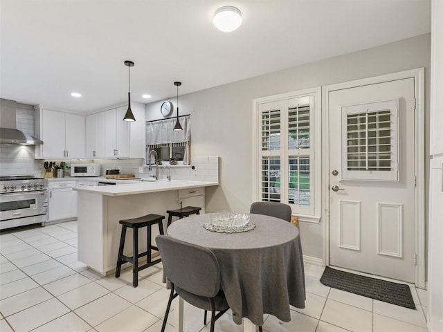 2626 Rivercrest Dr, Arlington, TX 76006 - kitchen with high end stainless steel range oven, white microwave, a peninsula, decorative backsplash, and recessed lighting