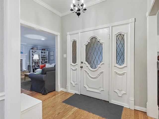2626 Rivercrest Dr, Arlington, TX 76006 - foyer entrance featuring ornamental molding, light wood-type flooring, a chandelier, a fireplace, and baseboards