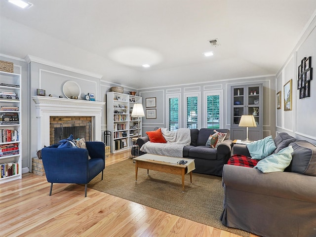 2626 Rivercrest Dr, Arlington, TX 76006 - living area featuring wood finished floors, a fireplace, built in shelves, a decorative wall, and ornamental molding