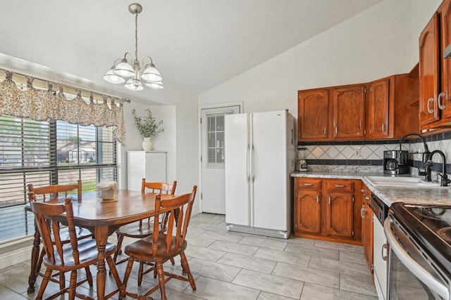 7600 Independence Dr, The Colony, TX 75056 - kitchen featuring freestanding refrigerator, lofted ceiling, a chandelier, decorative backsplash, and a sink