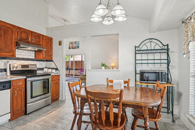 7600 Independence Dr, The Colony, TX 75056 - kitchen with stainless steel appliances, under cabinet range hood, vaulted ceiling, a chandelier, and tasteful backsplash