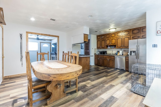 dining area with wood finished floors, a ceiling fan, and recessed lighting