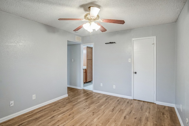 12480 Abrams Rd Unit 2801, Dallas, TX 75243 - unfurnished bedroom with light wood-style floors, a textured ceiling, baseboards, and a ceiling fan