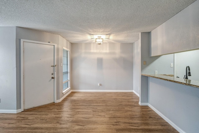 12480 Abrams Rd Unit 2801, Dallas, TX 75243 - unfurnished dining area with wood finished floors, baseboards, a textured ceiling, and a sink