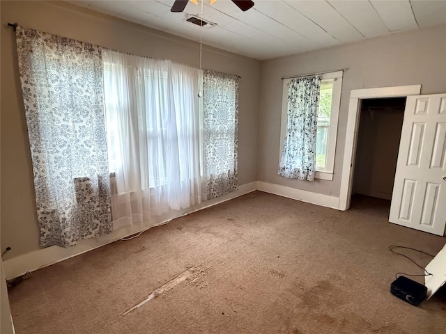 unfurnished dining area with ceiling fan, carpet floors, and baseboards