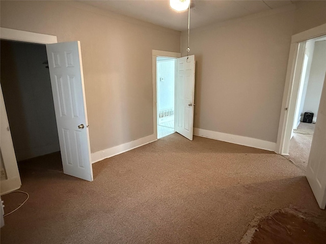 carpeted empty room featuring baseboards