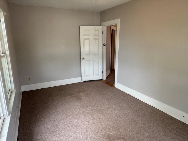 carpeted spare room with baseboards