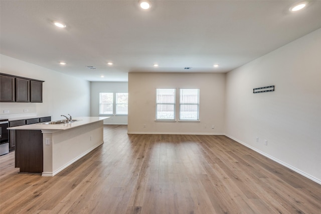 13156 Sanctuary Dr, Providence Village, TX 76227 - kitchen featuring a sink, a kitchen island with sink, dark brown cabinetry, light wood finished floors, and recessed lighting