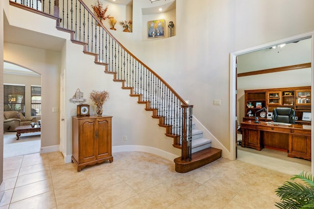 3455 Crosshaven Ln, Frisco, TX 75033 - stairway featuring a high ceiling, arched walkways, tile patterned flooring, and baseboards