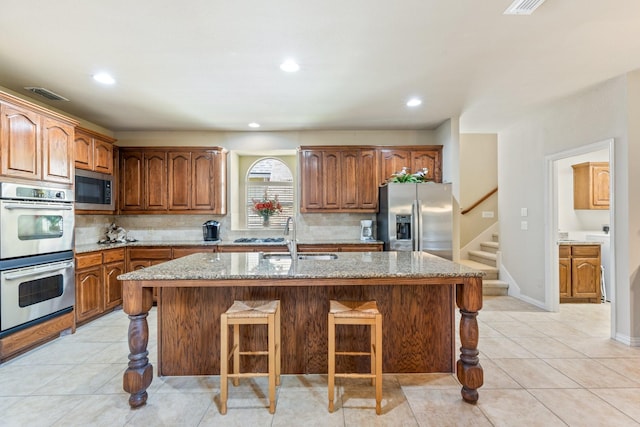 3455 Crosshaven Ln, Frisco, TX 75033 - kitchen with stainless steel appliances, a sink, decorative backsplash, a kitchen bar, and recessed lighting