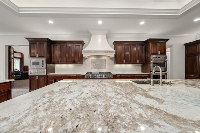 1020 Canyon Trl, Waco, TX 76657 - kitchen with custom exhaust hood, appliances with stainless steel finishes, a warming drawer, a sink, and light stone countertops