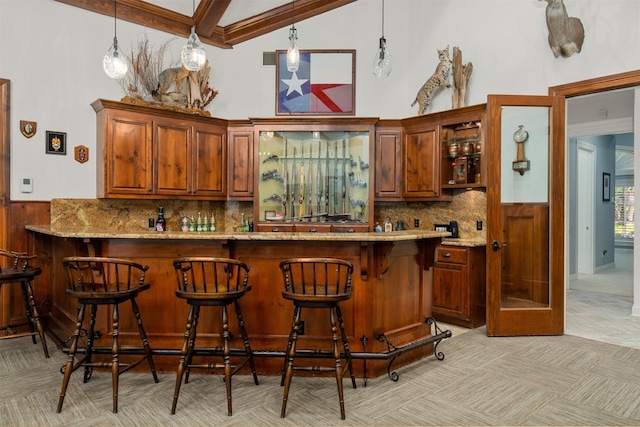 1020 Canyon Trl, Waco, TX 76657 - indoor bar featuring light carpet, wainscoting, wood walls, decorative backsplash, and high vaulted ceiling