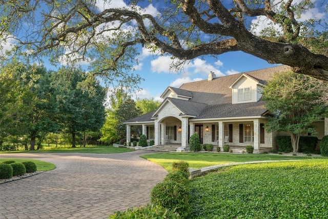 1020 Canyon Trl, Waco, TX 76657 - view of front of property featuring curved driveway, covered porch, a chimney, a front yard, and roof with shingles