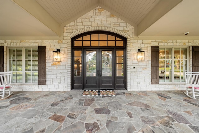 1020 Canyon Trl, Waco, TX 76657 - doorway to property with french doors, stone siding, a security system, and a porch