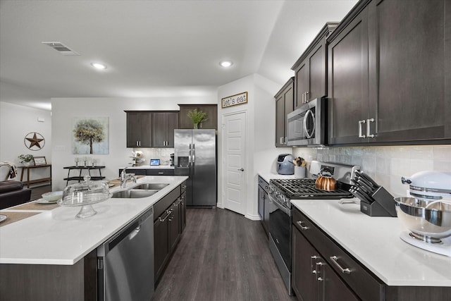 223 Exploration Way, Fate, TX 75189 - kitchen with appliances with stainless steel finishes, a sink, dark brown cabinetry, light countertops, and dark wood-style flooring