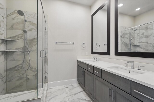 full bathroom with a stall shower, marble finish floors, double vanity, and baseboards