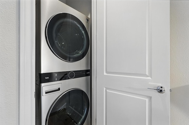 clothes washing area with stacked washing machine and dryer