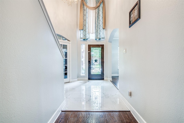 1407 Hickory Bend Dr, Allen, TX 75002 - entryway featuring arched walkways, marble tiled flooring, baseboards, a textured wall, and a high ceiling