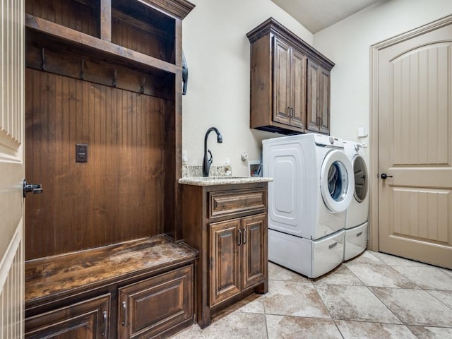 washroom with cabinet space and washer and clothes dryer