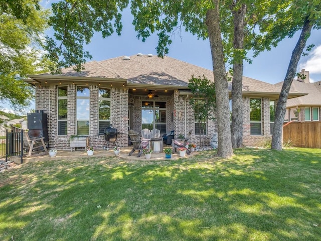 back of property with brick siding, a patio, a shingled roof, and ceiling fan