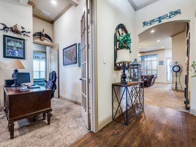 carpeted office with arched walkways, crown molding, wood finished floors, baseboards, and recessed lighting
