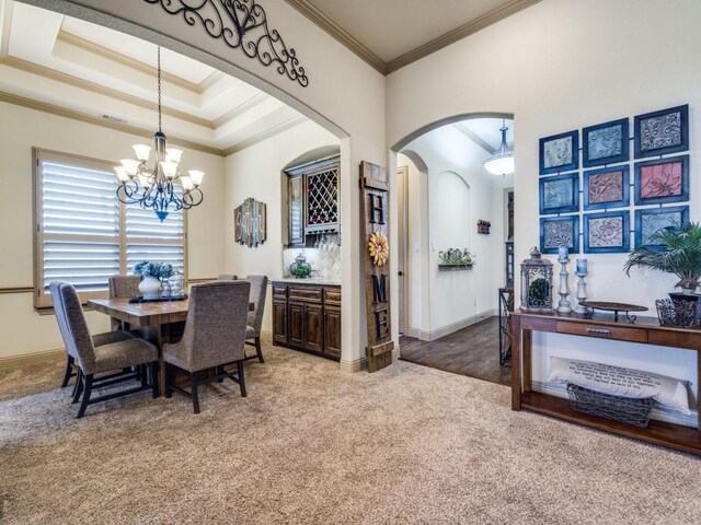 dining area with arched walkways, light colored carpet, a chandelier, ornamental molding, and baseboards