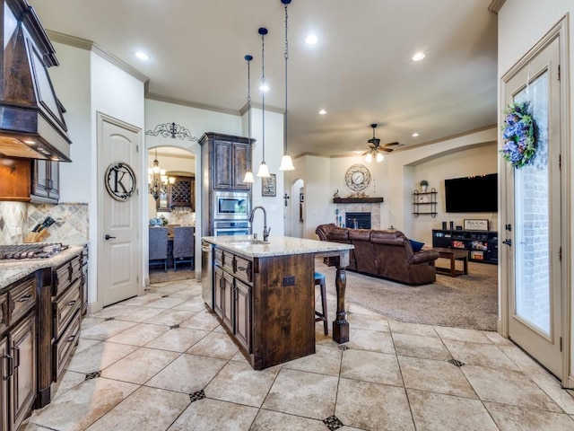 kitchen with ornamental molding, custom range hood, a chandelier, a breakfast bar, and ceiling fan