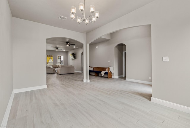 5585 Justine Pl, Fort Worth, TX 76126 - unfurnished living room with arched walkways, light wood-type flooring, baseboards, a chandelier, and a ceiling fan