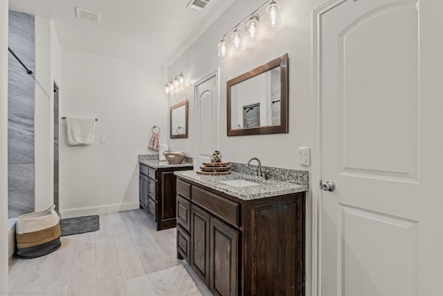 5585 Justine Pl, Fort Worth, TX 76126 - full bath with two vanities, wood finished floors, and baseboards