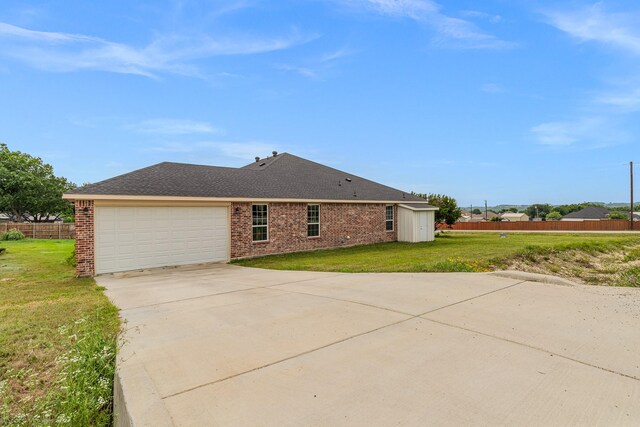 5585 Justine Pl, Fort Worth, TX 76126 - view of side of home with a garage, driveway, brick siding, and a shingled roof