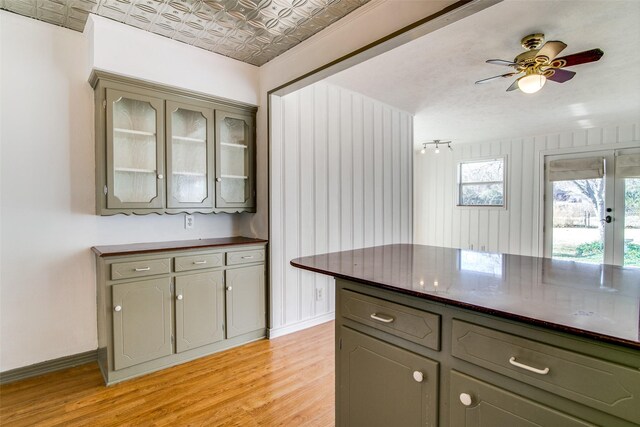 214 S Clark St, Rockwall, TX 75087 - kitchen with dark countertops, gray cabinets, light wood finished floors, glass insert cabinets, and an ornate ceiling