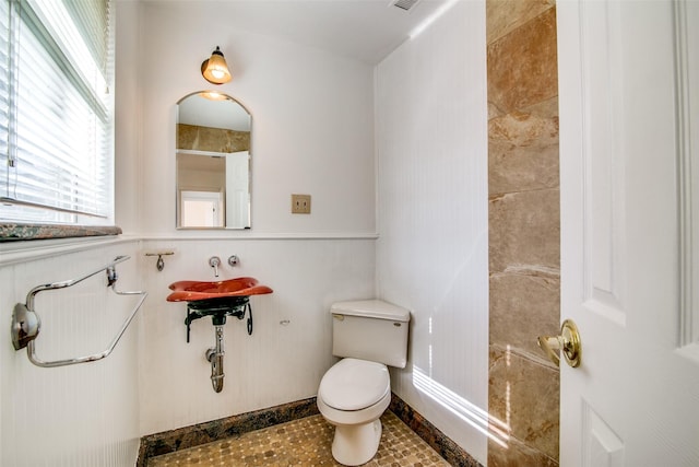 214 S Clark St, Rockwall, TX 75087 - bathroom with toilet and a wainscoted wall