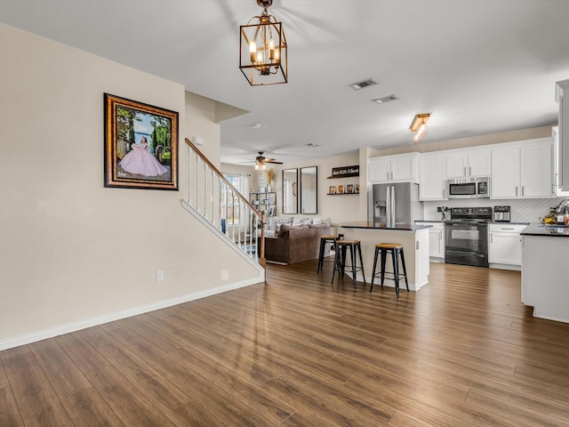 5221 Wheat Sheaf Trl, Fort Worth, TX 76179 - kitchen with appliances with stainless steel finishes, open floor plan, dark countertops, white cabinetry, and a breakfast bar area