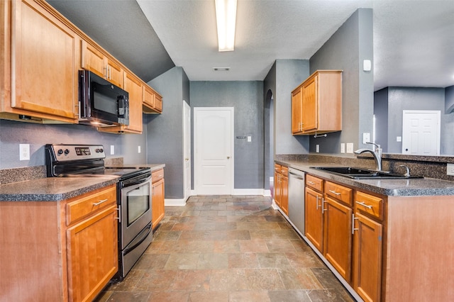 110 Commonwealth Cir, Waxahachie, TX 75165 - kitchen with stainless steel appliances, a sink, a peninsula, dark countertops, and baseboards