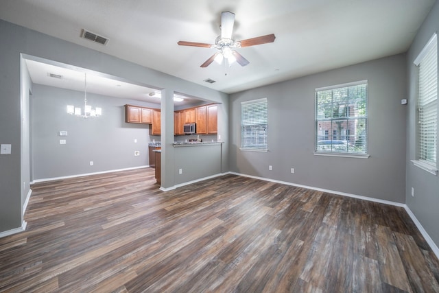 4928 Heather Glen Trl, Mckinney, TX 75070 - unfurnished living room featuring dark wood-type flooring, a chandelier, ceiling fan, and baseboards