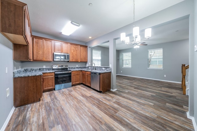 4928 Heather Glen Trl, Mckinney, TX 75070 - kitchen featuring stainless steel appliances, a chandelier, wood finished floors, and a sink