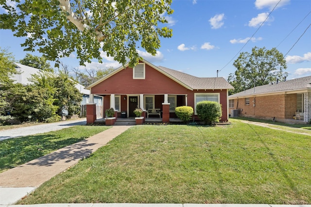 bungalow-style house featuring a porch, a front lawn, and cooling unit